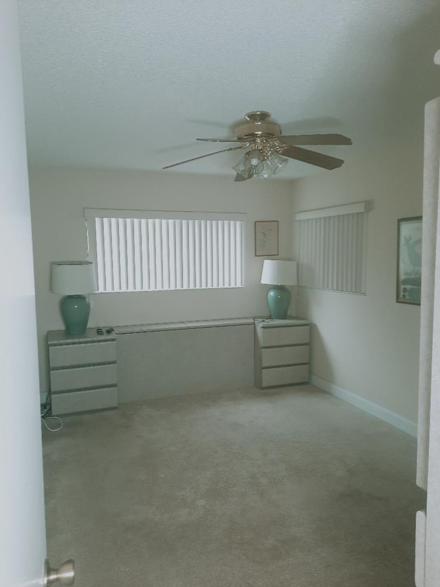 spare room with carpet flooring, a ceiling fan, and a textured ceiling