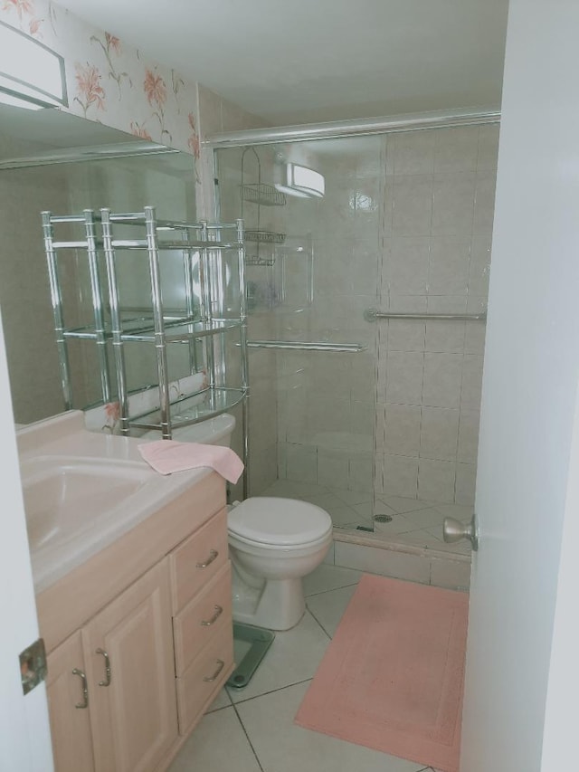 full bath featuring tile patterned flooring, a shower stall, vanity, and toilet