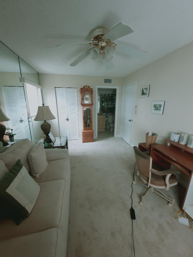 carpeted living area featuring ceiling fan