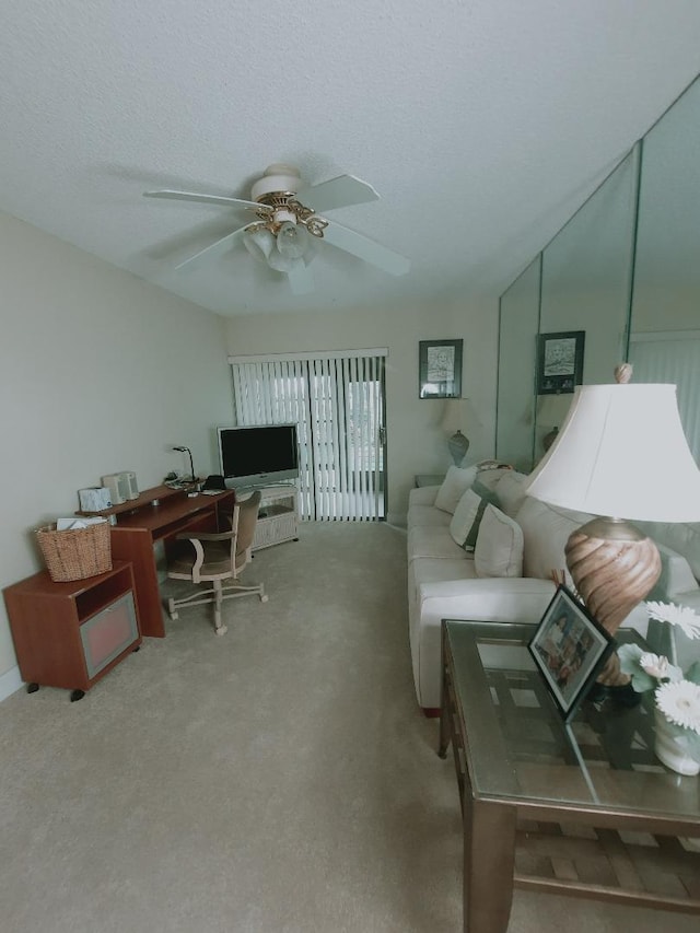 living room featuring carpet floors, a ceiling fan, and a textured ceiling