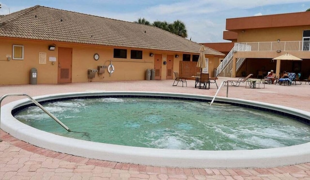 community pool with stairway and a patio