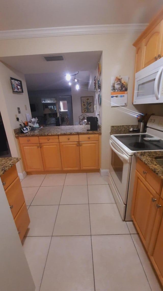 kitchen with white appliances, ornamental molding, light tile patterned flooring, dark stone countertops, and light brown cabinets