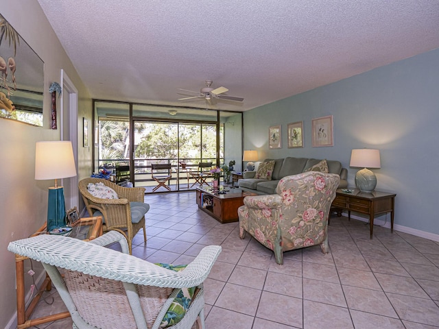 living area featuring a textured ceiling, a wall of windows, baseboards, ceiling fan, and light tile patterned floors