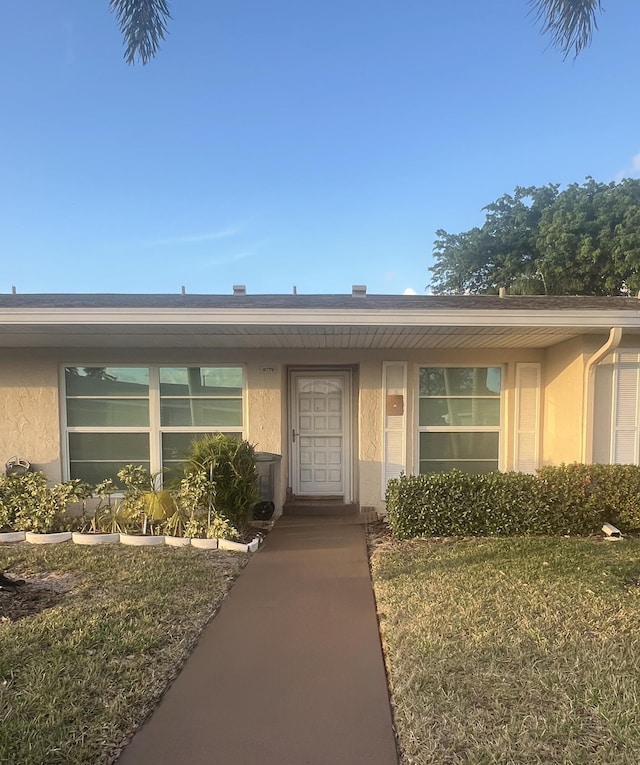 view of front of house featuring stucco siding and a front yard