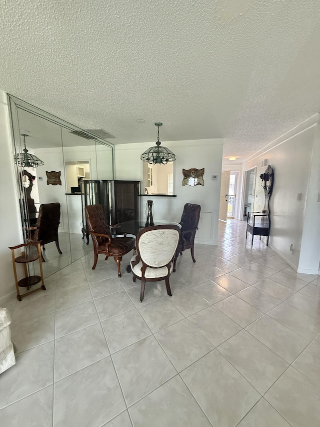tiled dining space with a notable chandelier, a textured ceiling, and crown molding