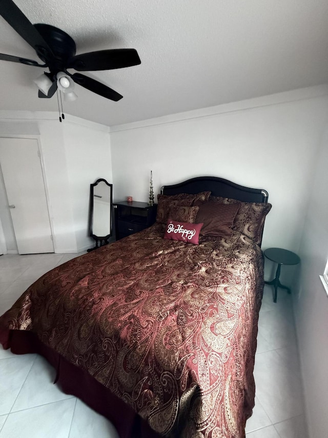 tiled bedroom with a textured ceiling, ceiling fan, and crown molding