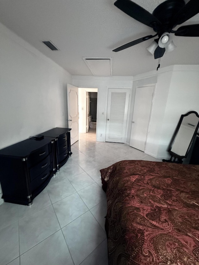 bedroom with light tile patterned floors, visible vents, and a ceiling fan