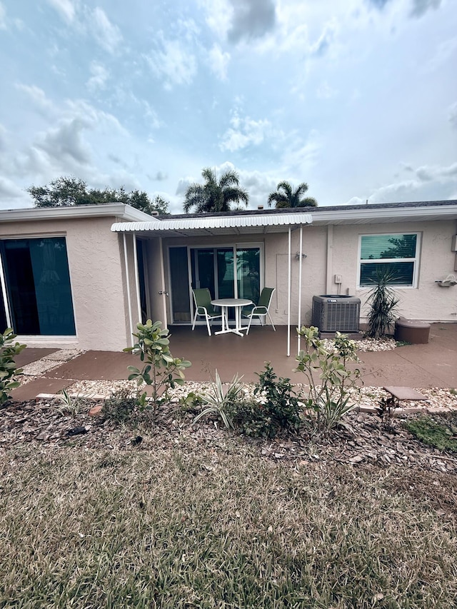 back of house featuring stucco siding, central AC, and a patio area