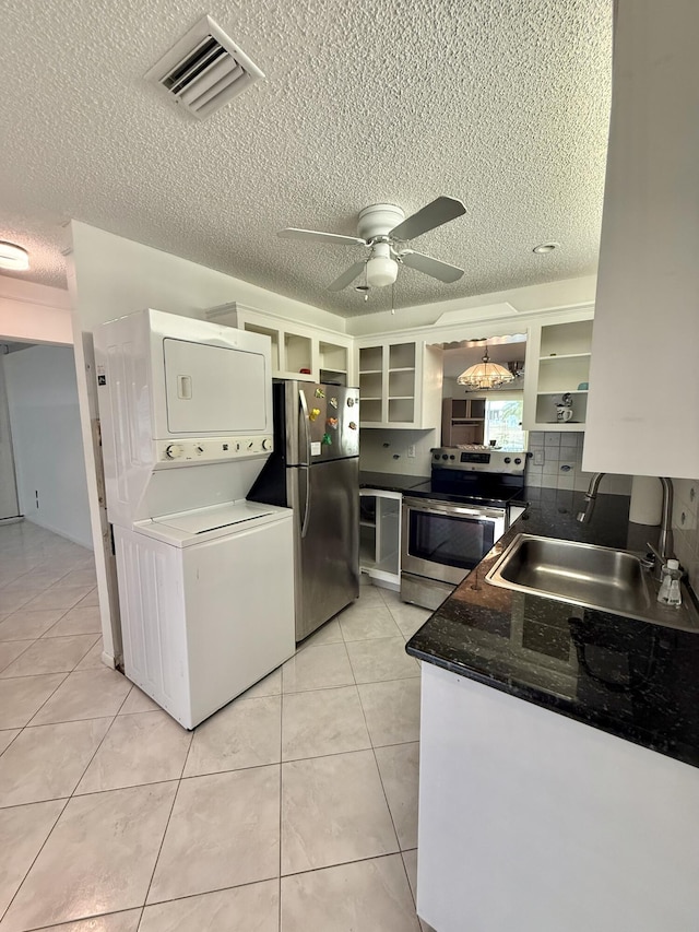 kitchen with visible vents, ceiling fan, appliances with stainless steel finishes, stacked washing maching and dryer, and open shelves