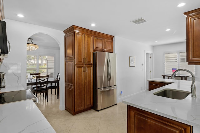 6611 NE 21st Ln, Fort Lauderdale, FL 33308 - kitchen with visible vents, a sink, light stone counters, and freestanding refrigerator