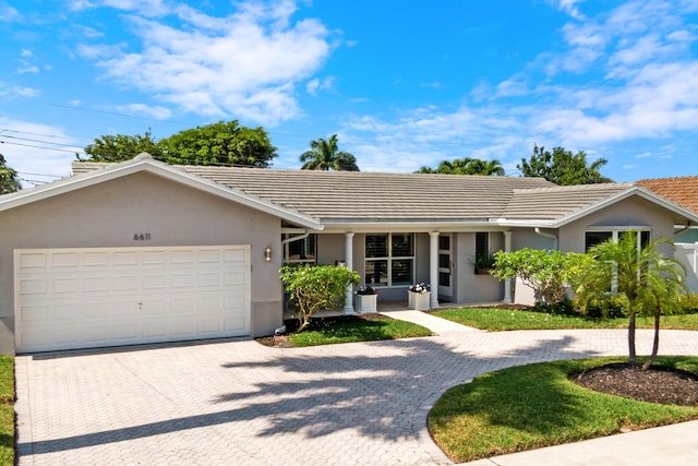 6611 NE 21st Ln, Fort Lauderdale, FL 33308 - single story home with stucco siding, an attached garage, a tiled roof, and decorative driveway