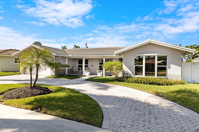 6611 NE 21st Ln, Fort Lauderdale, FL 33308 - ranch-style home featuring a front lawn, decorative driveway, stucco siding, and a garage