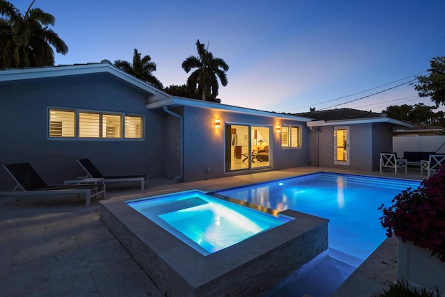 6611 NE 21st Ln, Fort Lauderdale, FL 33308 - pool at dusk featuring a patio, an outdoor pool, and an in ground hot tub