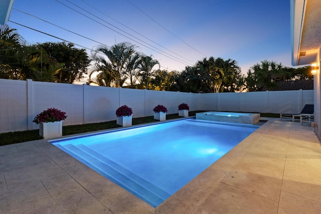 6611 NE 21st Ln, Fort Lauderdale, FL 33308 - pool at dusk with a fenced backyard, a pool with connected hot tub, and a patio