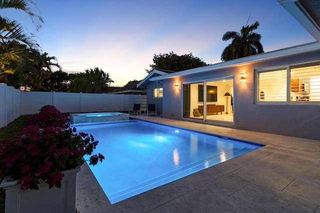6611 NE 21st Ln, Fort Lauderdale, FL 33308 - pool at dusk featuring a fenced backyard, a pool with connected hot tub, and a patio area