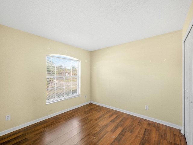 empty room with wood finished floors and baseboards