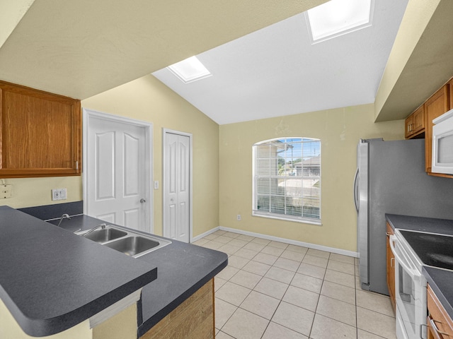 kitchen with a sink, dark countertops, white appliances, a peninsula, and lofted ceiling