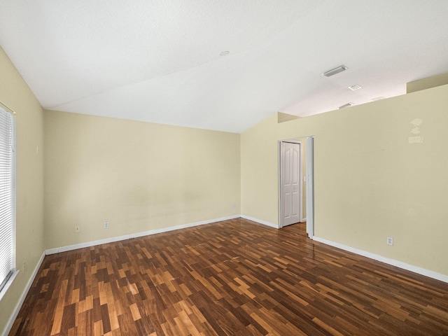 unfurnished room featuring baseboards, lofted ceiling, and wood finished floors