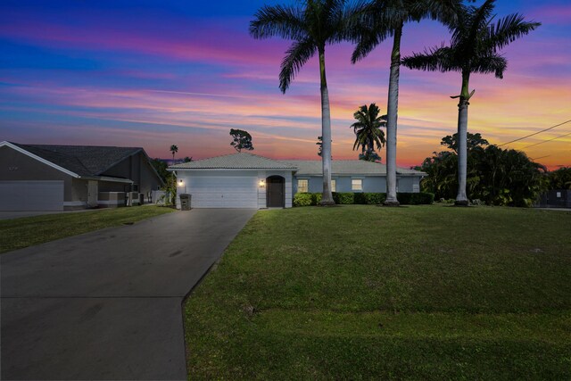 131 NE Naranja Ave, Port Saint Lucie, FL 34983 - ranch-style home featuring a tiled roof, an attached garage, concrete driveway, and a front yard
