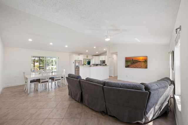 131 NE Naranja Ave, Port Saint Lucie, FL 34983 - living area with light tile patterned floors, a ceiling fan, baseboards, vaulted ceiling, and a textured ceiling