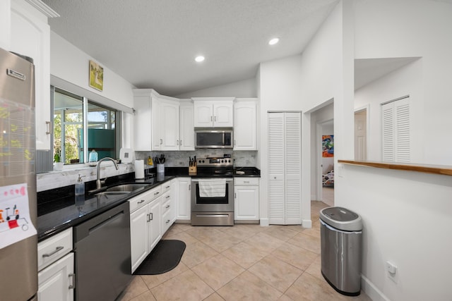 131 NE Naranja Ave, Port Saint Lucie, FL 34983 - kitchen with light tile patterned floors, a sink, stainless steel appliances, white cabinetry, and backsplash