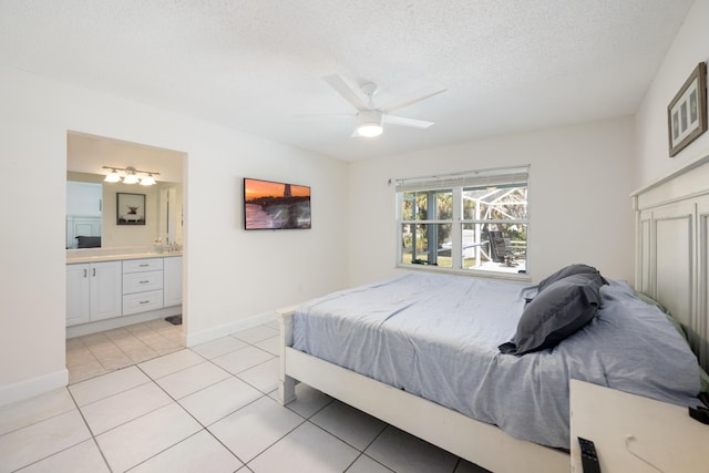 131 NE Naranja Ave, Port Saint Lucie, FL 34983 - bedroom featuring connected bathroom, baseboards, light tile patterned flooring, a textured ceiling, and a ceiling fan
