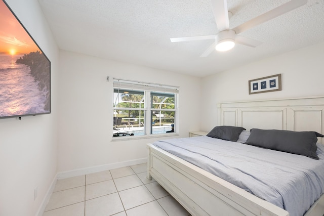 131 NE Naranja Ave, Port Saint Lucie, FL 34983 - bedroom with ceiling fan, baseboards, a textured ceiling, and light tile patterned flooring