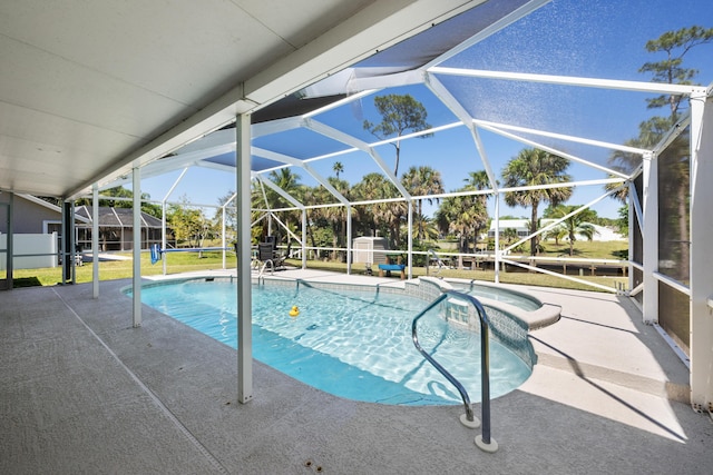 131 NE Naranja Ave, Port Saint Lucie, FL 34983 - view of swimming pool with glass enclosure, a patio, a lawn, and a pool with connected hot tub