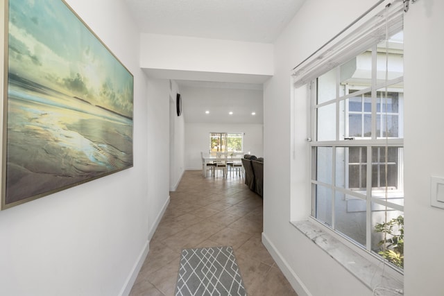 131 NE Naranja Ave, Port Saint Lucie, FL 34983 - corridor with tile patterned flooring, a textured ceiling, and baseboards