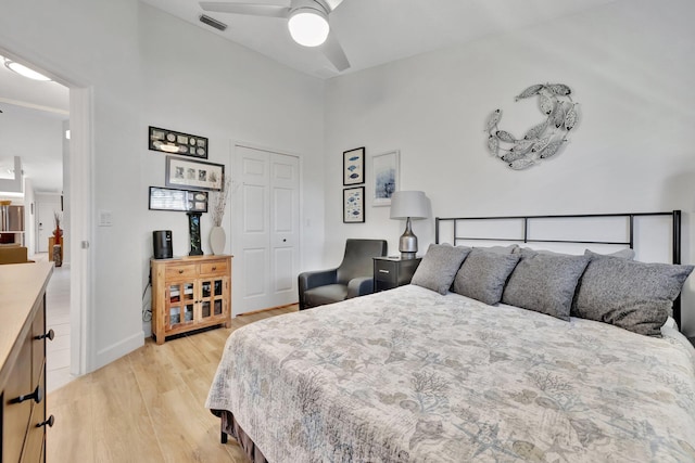 bedroom featuring visible vents, light wood-style flooring, a closet, baseboards, and ceiling fan
