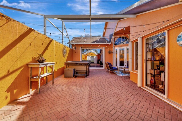 view of patio featuring a lanai and a hot tub