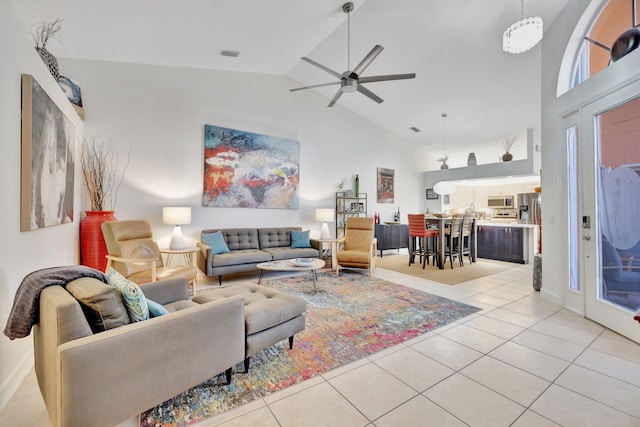 living room with light tile patterned floors, high vaulted ceiling, and a ceiling fan