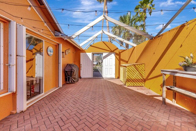 view of patio featuring glass enclosure