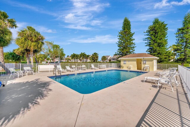 pool with a patio and fence