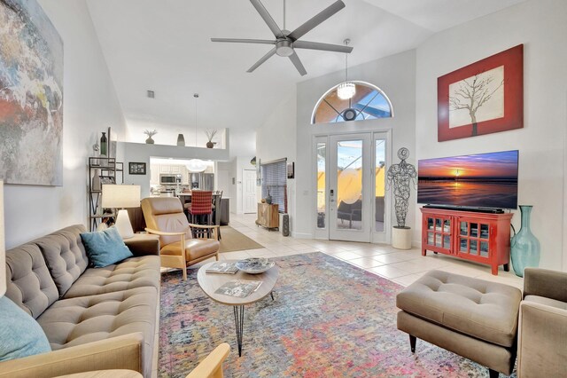 living room featuring light tile patterned flooring, a towering ceiling, and ceiling fan