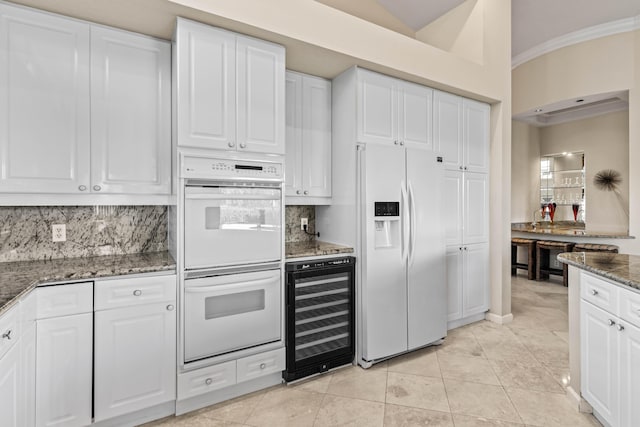 16137 Via Monteverde, Delray Beach, FL 33446 - kitchen featuring wine cooler, white cabinetry, dark stone countertops, white appliances, and decorative backsplash