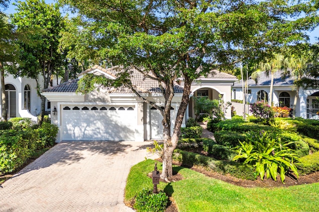 16137 Via Monteverde, Delray Beach, FL 33446 - view of front of house with a tile roof, decorative driveway, an attached garage, and stucco siding