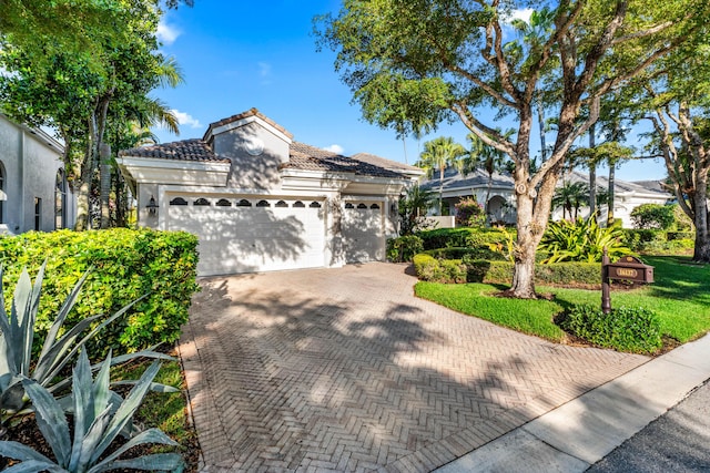 16137 Via Monteverde, Delray Beach, FL 33446 - view of front facade featuring a tile roof, decorative driveway, a garage, and stucco siding