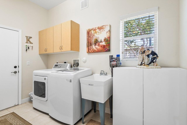 clothes washing area with cabinet space, washing machine and dryer, visible vents, and light tile patterned floors
