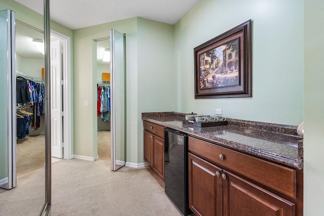 bar featuring baseboards, a textured ceiling, refrigerator, and light colored carpet