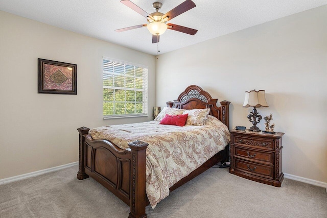 bedroom featuring ceiling fan, baseboards, and light colored carpet