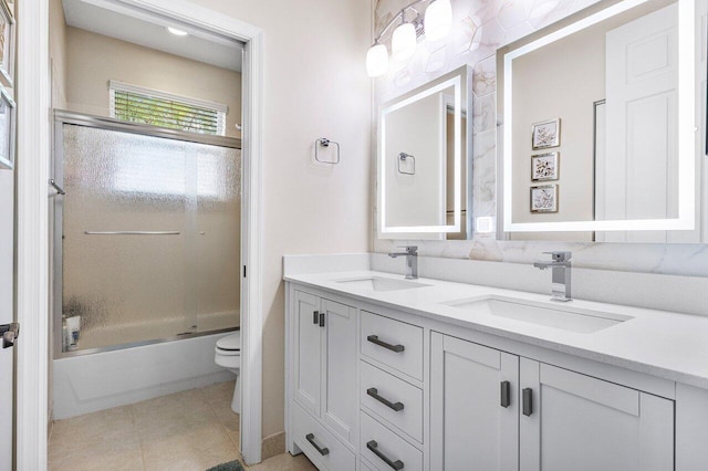 full bathroom featuring toilet, tile patterned floors, a sink, and double vanity