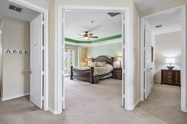 bedroom featuring light carpet, baseboards, visible vents, and a textured ceiling