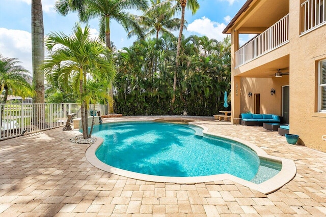 view of swimming pool featuring outdoor lounge area, a fenced in pool, a ceiling fan, and a patio