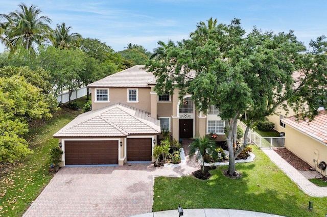 view of front of home with driveway, a tiled roof, fence, a front yard, and stucco siding