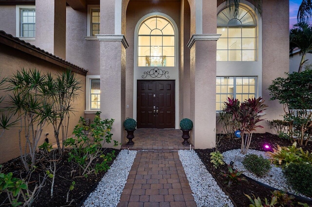 view of exterior entry featuring stucco siding