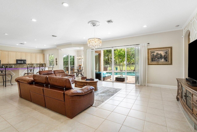 living room with a healthy amount of sunlight, a chandelier, visible vents, and light tile patterned floors