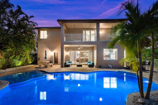 exterior space with an outdoor living space, an outdoor pool, a ceiling fan, french doors, and a patio