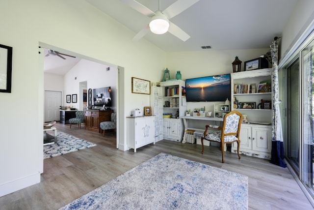 office space featuring vaulted ceiling, visible vents, a ceiling fan, wood finished floors, and baseboards