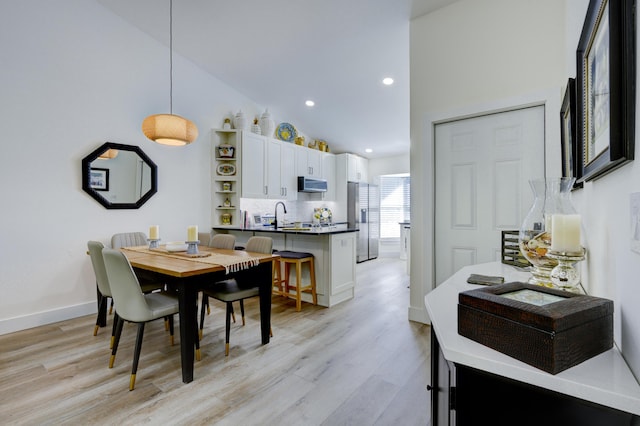 dining area with light wood finished floors, baseboards, recessed lighting, and lofted ceiling